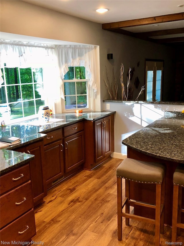 6567 Heaven Dr, Howell, MI 48855 - kitchen with light wood finished floors, dark stone countertops, and beam ceiling
