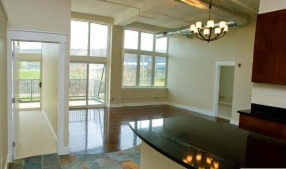 600 NW Broadway Ave Unit 318, Grand Rapids, MI 49504 - kitchen with a chandelier, dark countertops, baseboards, a high ceiling, and decorative light fixtures