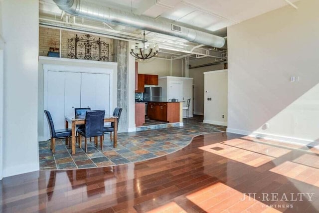 600 NW Broadway Ave Unit 318, Grand Rapids, MI 49504 - dining space featuring dark wood-style flooring, a chandelier, and a high ceiling