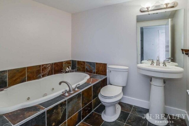 600 NW Broadway Ave Unit 318, Grand Rapids, MI 49504 - bathroom with a whirlpool tub, toilet, and baseboards