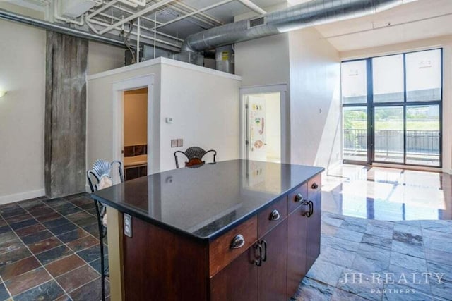 600 NW Broadway Ave Unit 318, Grand Rapids, MI 49504 - kitchen with dark countertops, dark stone finish floors, a breakfast bar area, and a kitchen island