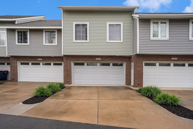 302 NE Xing, Holland, MI 49423 - view of front of house featuring brick siding, driveway, and a garage