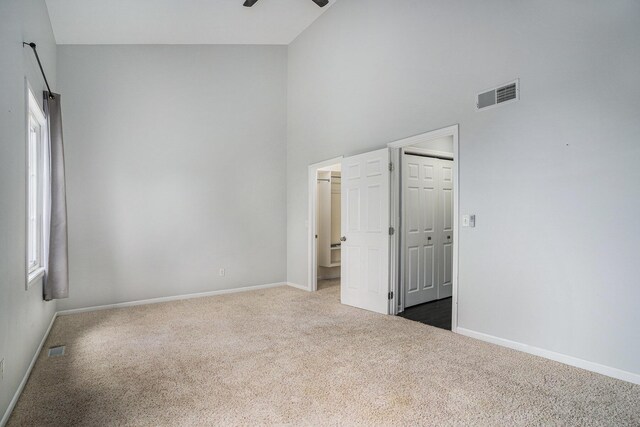 302 NE Xing, Holland, MI 49423 - carpeted spare room featuring a ceiling fan, a towering ceiling, and baseboards