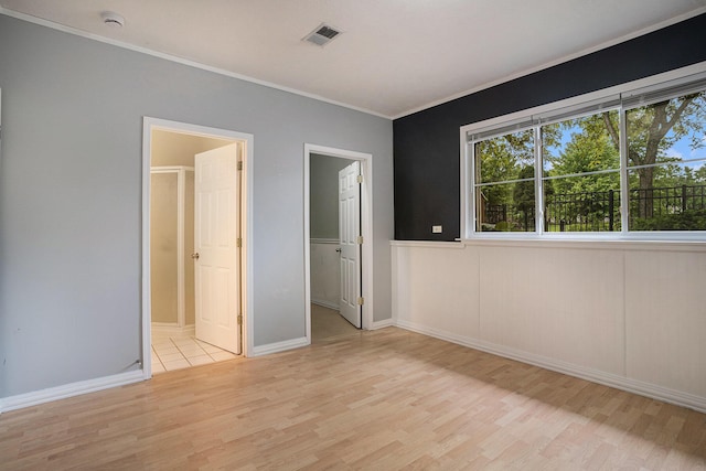 302 NE Xing, Holland, MI 49423 - unfurnished bedroom with light wood-style flooring, crown molding, and a spacious closet