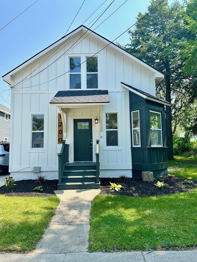 1200 Pine St, Muskegon, MI 49442 - modern farmhouse with board and batten siding, a front lawn, and roof with shingles