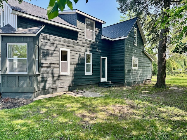1200 Pine St, Muskegon, MI 49442 - rear view of house with entry steps, a lawn, and a shingled roof