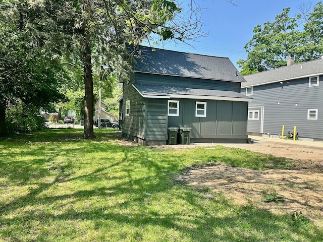 1200 Pine St, Muskegon, MI 49442 - rear view of property with a shingled roof and a lawn
