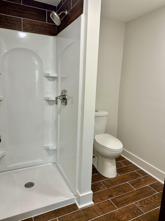 1200 Pine St, Muskegon, MI 49442 - full bathroom featuring a stall shower, wood finish floors, toilet, and baseboards