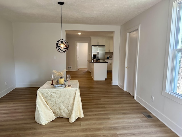 1200 Pine St, Muskegon, MI 49442 - dining room featuring light wood-style floors, baseboards, and a textured ceiling