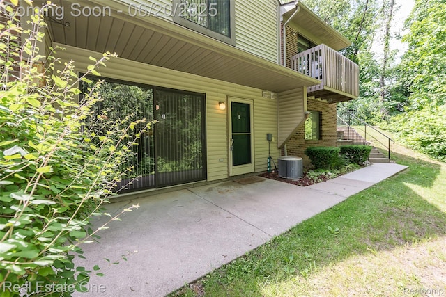 410 Spring Brooke Dr, Brighton, MI 48116 - doorway to property featuring a balcony, brick siding, and a patio area
