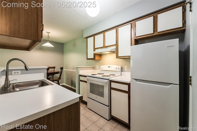 410 Spring Brooke Dr, Brighton, MI 48116 - kitchen featuring white appliances, under cabinet range hood, light countertops, light tile patterned floors, and a textured ceiling