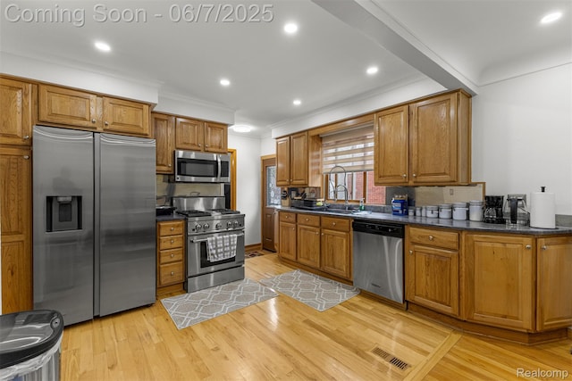 8786 N Evangeline St, Dearborn Heights, MI 48127 - kitchen featuring appliances with stainless steel finishes, dark countertops, ornamental molding, light wood finished floors, and brown cabinets