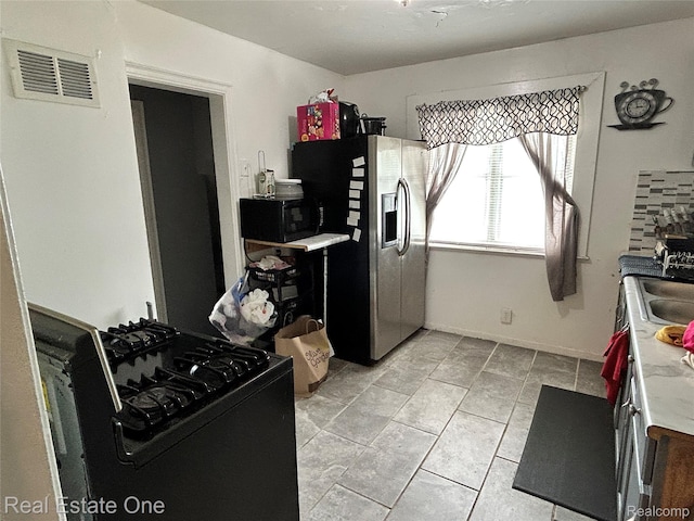16857 Cheyenne St, Detroit, MI 48235 - kitchen featuring black appliances, light tile patterned floors, and light countertops