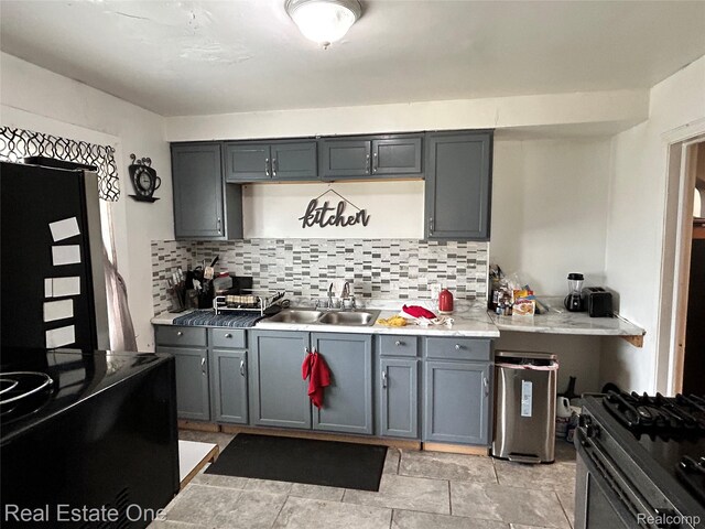 16857 Cheyenne St, Detroit, MI 48235 - kitchen with gas range, tasteful backsplash, gray cabinetry, and light countertops
