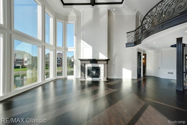 4087 Araby Ct, Highland, MI 48356 - unfurnished living room with a towering ceiling, a premium fireplace, healthy amount of natural light, a decorative wall, and wood finished floors