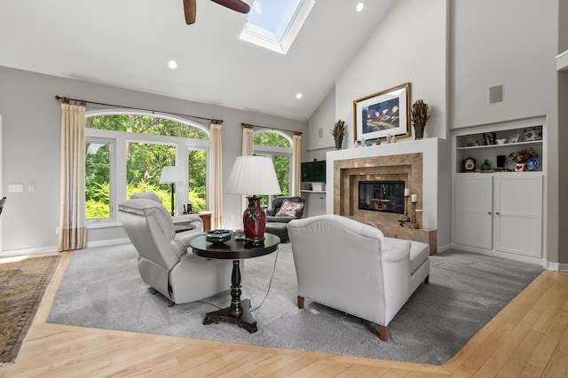 7843 Shepherds Glen Ct, Kalamazoo, MI 49009 - living area with ceiling fan, a high end fireplace, a skylight, wood finished floors, and high vaulted ceiling