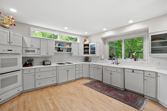 7843 Shepherds Glen Ct, Kalamazoo, MI 49009 - kitchen with white appliances, a sink, plenty of natural light, open shelves, and recessed lighting