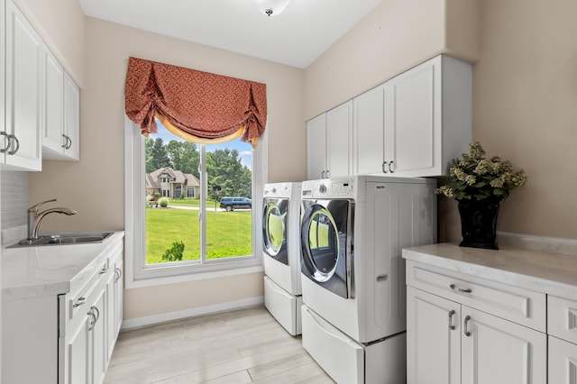 7843 Shepherds Glen Ct, Kalamazoo, MI 49009 - washroom with cabinet space, independent washer and dryer, light wood finished floors, and baseboards