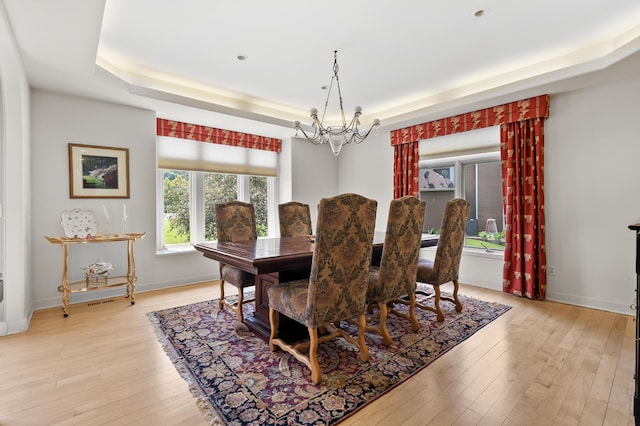 7843 Shepherds Glen Ct, Kalamazoo, MI 49009 - dining room with a tray ceiling, a chandelier, light wood-type flooring, and baseboards