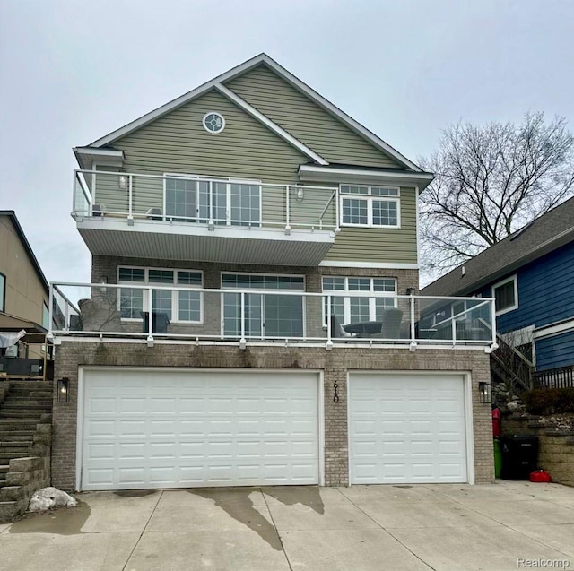 610 Longpointe Dr, Lake Orion, MI 48362 - view of front of house with a balcony, brick siding, concrete driveway, an attached garage, and stairway