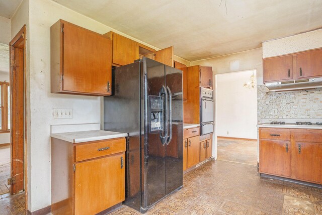 61473 M 40, Paw Paw, MI 49079 - kitchen with black refrigerator with ice dispenser, under cabinet range hood, a warming drawer, wall oven, and gas stovetop