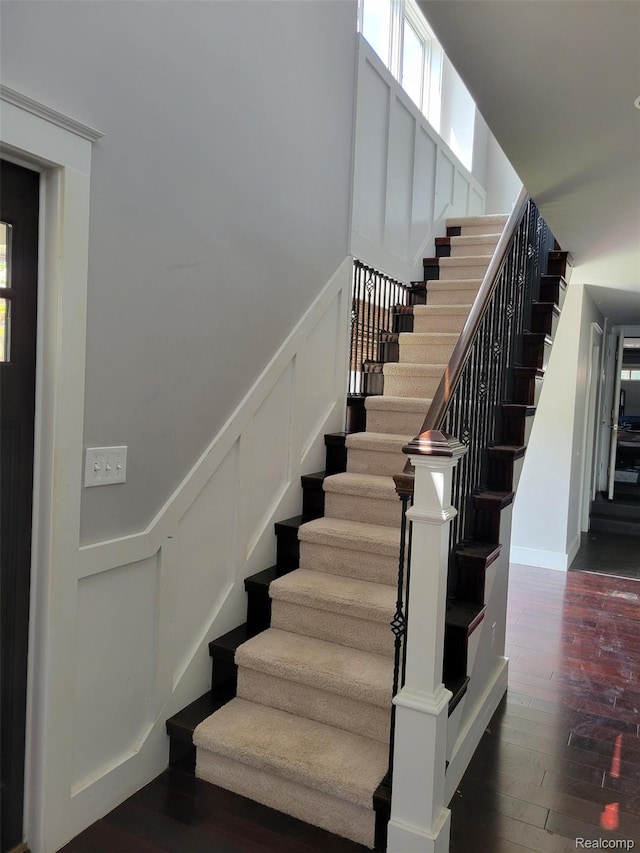 9635 Norman Rd, Clarkston, MI 48348 - stairs with wood finished floors, a decorative wall, plenty of natural light, and wainscoting