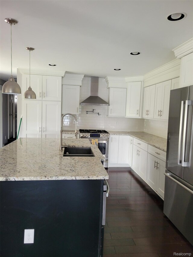 9635 Norman Rd, Clarkston, MI 48348 - kitchen featuring wall chimney range hood, appliances with stainless steel finishes, an island with sink, backsplash, and white cabinetry