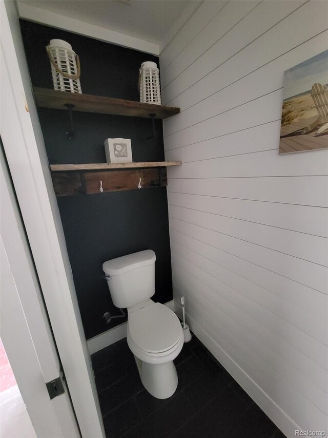 9635 Norman Rd, Clarkston, MI 48348 - bathroom with toilet, tile patterned floors, and wooden walls