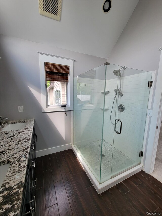 9635 Norman Rd, Clarkston, MI 48348 - full bathroom with wood finished floors, a stall shower, vanity, and baseboards