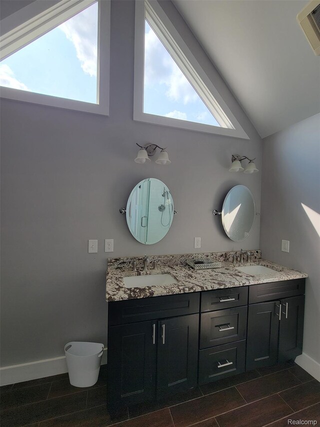 9635 Norman Rd, Clarkston, MI 48348 - bathroom featuring double vanity, toilet, wood tiled floors, lofted ceiling, and baseboards