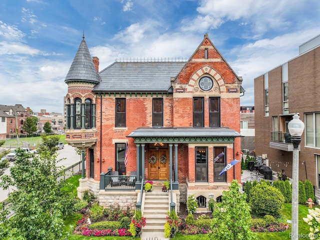 205 Alfred St Unit A, Detroit, MI 48201 - view of front facade featuring brick siding, a high end roof, and covered porch