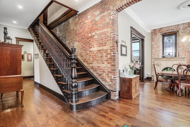 205 Alfred St Unit A, Detroit, MI 48201 - stairs with crown molding, wood finished floors, baseboards, and brick wall