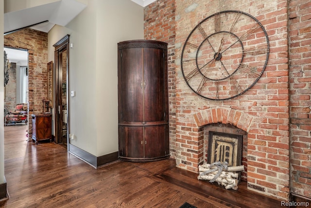 205 Alfred St Unit A, Detroit, MI 48201 - unfurnished living room featuring wood finished floors, baseboards, and brick wall