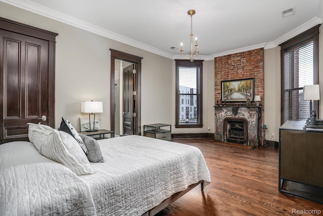 205 Alfred St Unit A, Detroit, MI 48201 - bedroom with a brick fireplace, dark wood-style flooring, crown molding, baseboards, and a chandelier