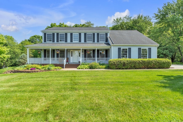 6676 Ralaric Dr, Dexter, MI 48130 - colonial home featuring a front lawn and a porch