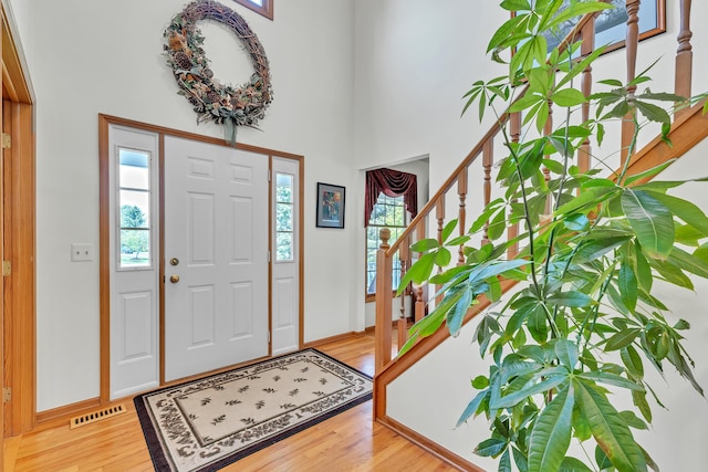 6676 Ralaric Dr, Dexter, MI 48130 - entryway with healthy amount of natural light, stairs, light wood-style flooring, and a high ceiling