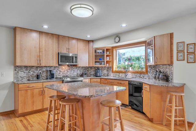 6676 Ralaric Dr, Dexter, MI 48130 - kitchen with appliances with stainless steel finishes, a kitchen bar, light wood finished floors, and recessed lighting