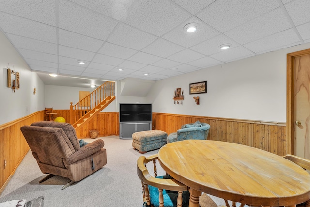 6676 Ralaric Dr, Dexter, MI 48130 - living room featuring a wainscoted wall, wooden walls, stairs, a paneled ceiling, and carpet floors