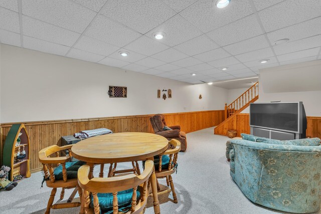 6676 Ralaric Dr, Dexter, MI 48130 - dining space featuring wainscoting, carpet flooring, a paneled ceiling, wood walls, and stairs