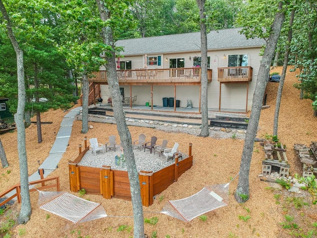 8833 W Velt Ave, Baldwin, MI 49304 - rear view of property featuring a wooden deck, a fire pit, a patio, and a shingled roof