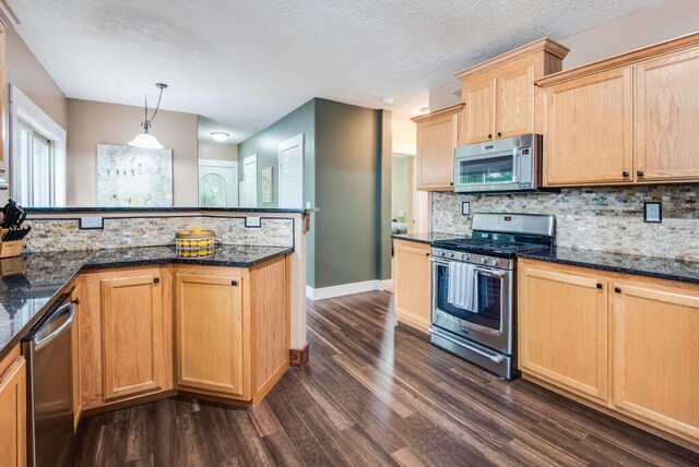 8833 W Velt Ave, Baldwin, MI 49304 - kitchen with appliances with stainless steel finishes, dark wood finished floors, decorative backsplash, baseboards, and a textured ceiling