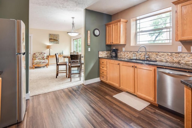 8833 W Velt Ave, Baldwin, MI 49304 - kitchen with stainless steel appliances, a sink, dark wood-type flooring, decorative light fixtures, and baseboards
