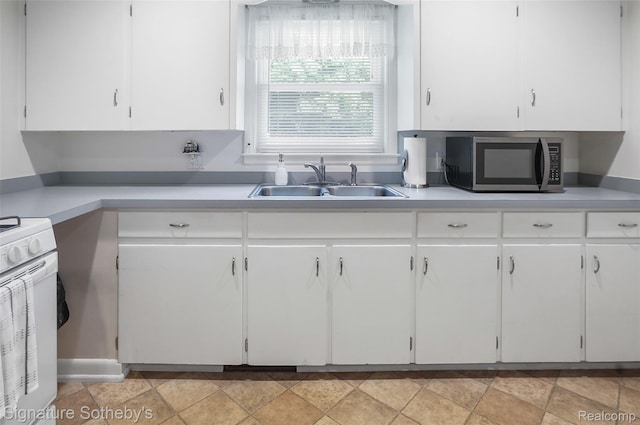300 Cornell St, Howell, MI 48843 - kitchen featuring stainless steel microwave, a sink, white cabinetry, and white gas range oven