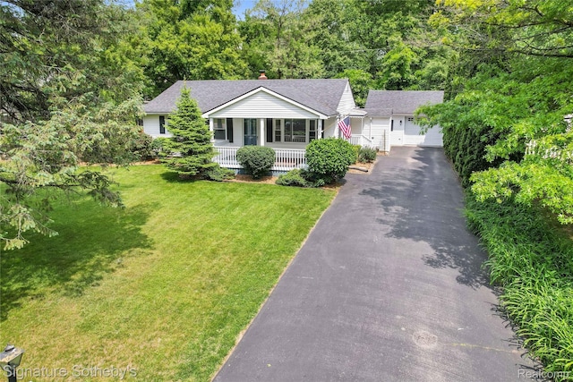 300 Cornell St, Howell, MI 48843 - view of front of property with covered porch, a front lawn, a garage, an outdoor structure, and a chimney