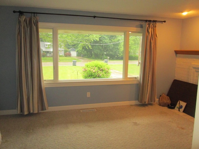 6005 Saint Joseph Ave, Stevensville, MI 49127 - carpeted empty room featuring healthy amount of natural light, a brick fireplace, and baseboards