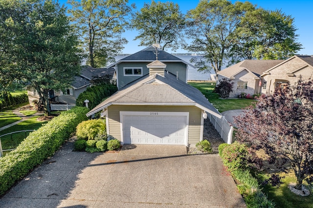 2585 Memorial Dr, Muskegon, MI 49445 - view of front of house featuring a garage, driveway, and roof with shingles