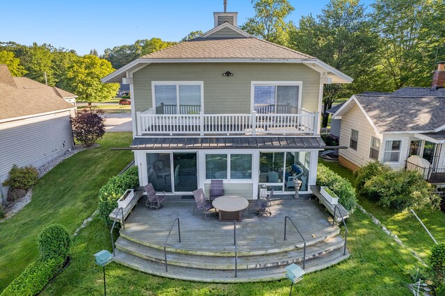 2585 Memorial Dr, Muskegon, MI 49445 - back of property featuring a balcony, a yard, a patio area, a wooden deck, and a chimney