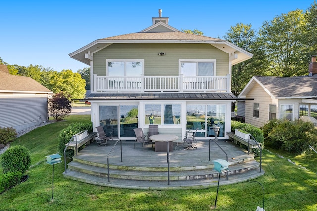 2585 Memorial Dr, Muskegon, MI 49445 - rear view of house with a balcony, a lawn, and a chimney