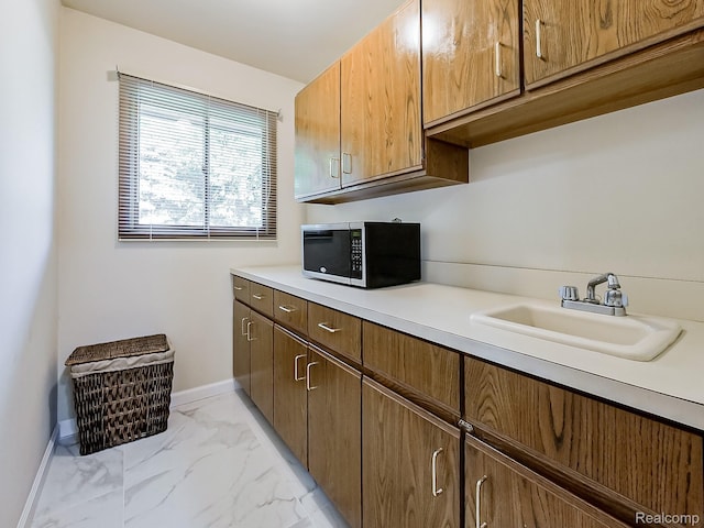 3849 Barg Dr, Warren, MI 48310 - kitchen with stainless steel microwave, a sink, baseboards, light marble finish flooring, and light countertops