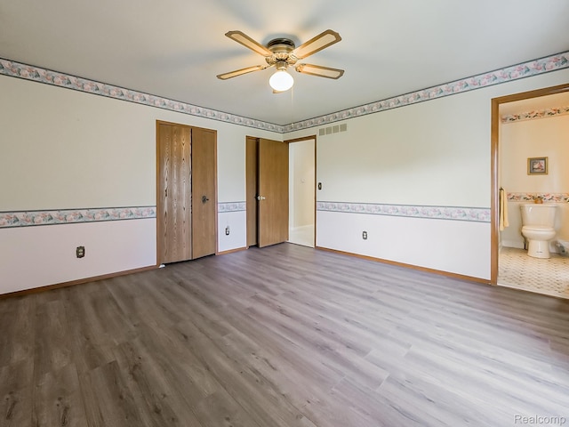3849 Barg Dr, Warren, MI 48310 - unfurnished bedroom featuring wood finished floors, baseboards, multiple closets, connected bathroom, and ceiling fan